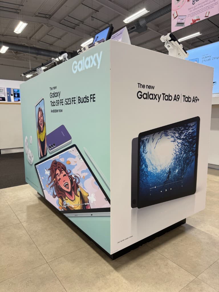 Branded retail POS island wrapped in vinyl graphics.