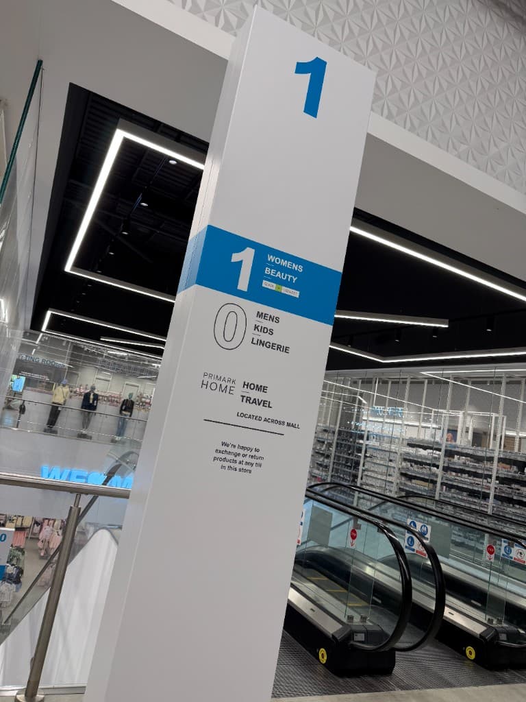 Primark Manchester directional totem pole — wrapped signage