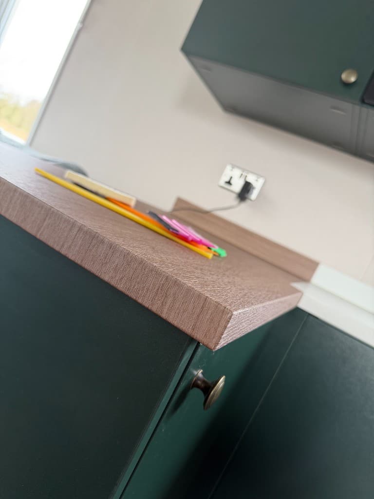 Close-up of wrapped kitchen cabinets and stone-style counters