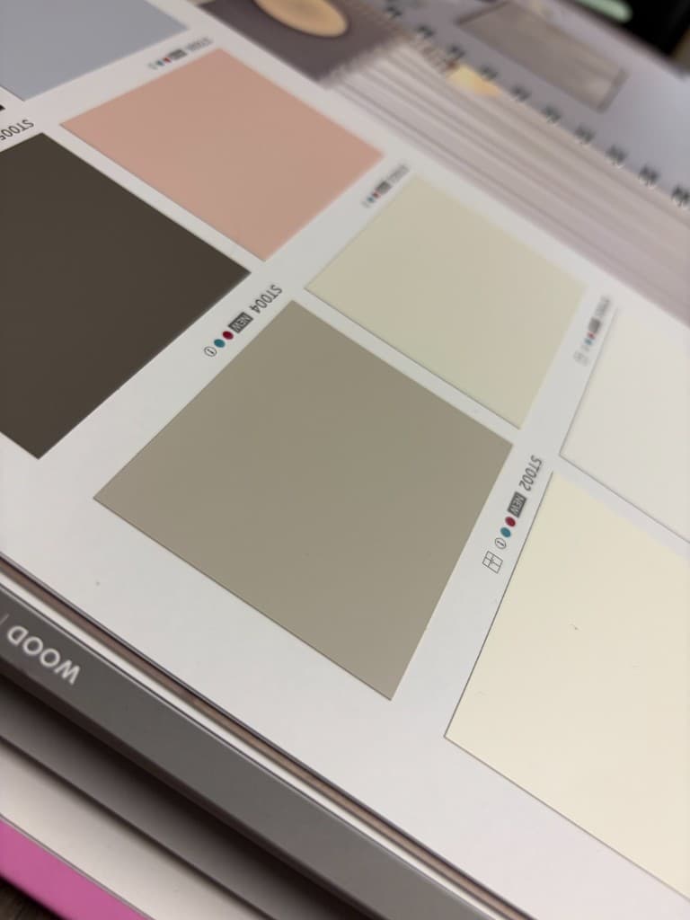 Kitchen wrap sample book showing neutral architectural vinyl finish tones