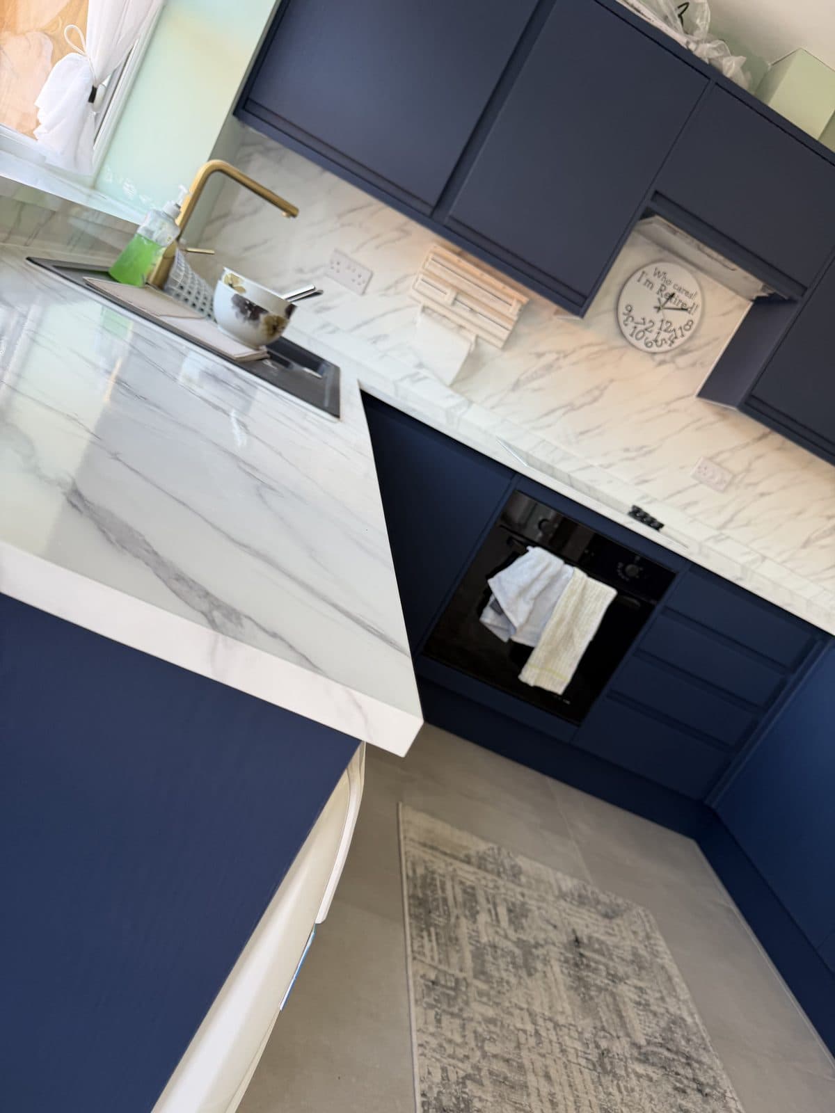 Navy kitchen wrap Doncaster — angled view of marble worktop and navy cabinets after