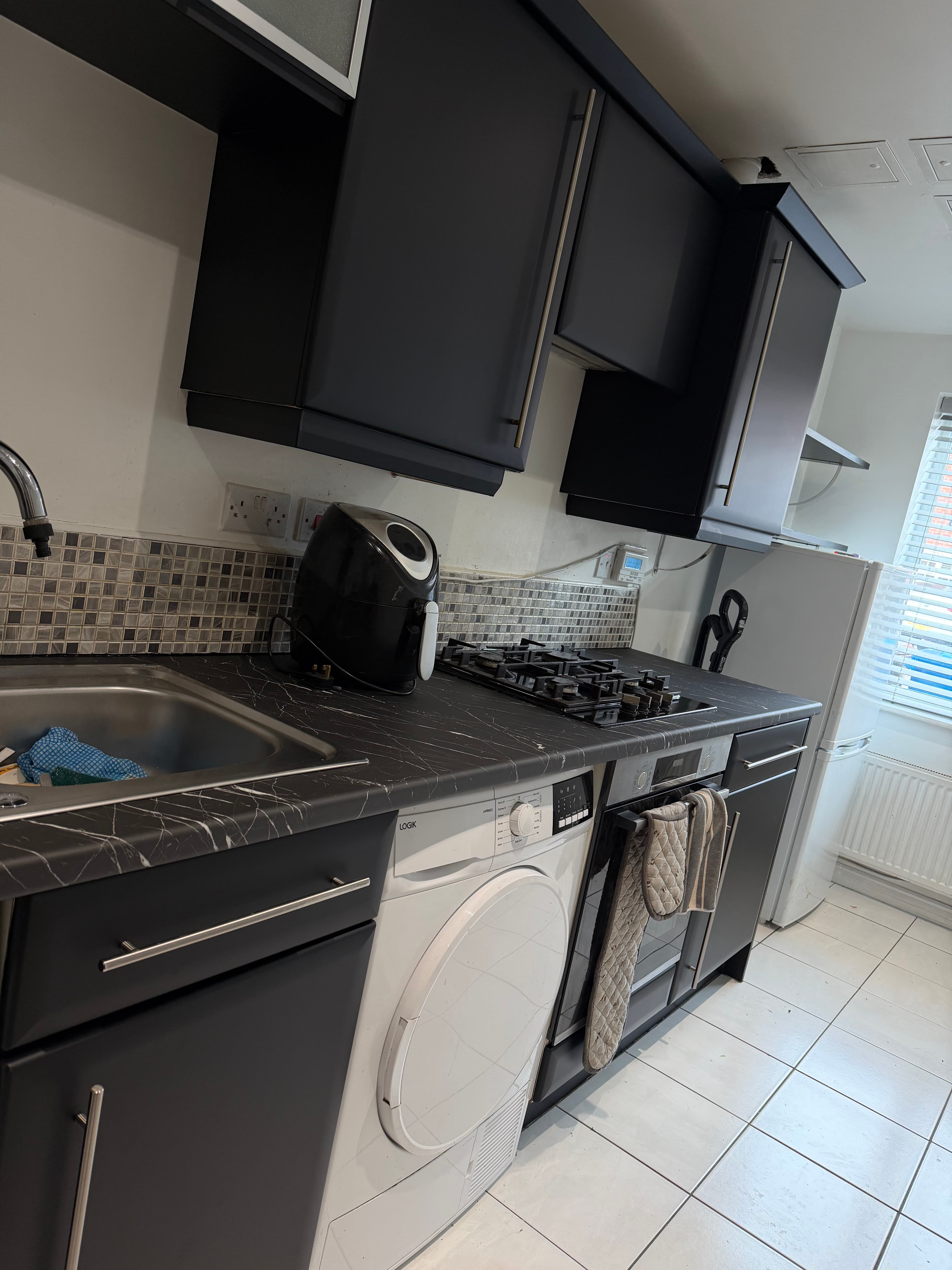 Black kitchen wrap Sheffield — lower cabinet and hob area after