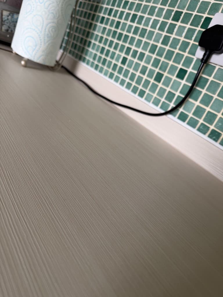 Chesterfield worktop wrap project — white wood-effect vinyl close-up